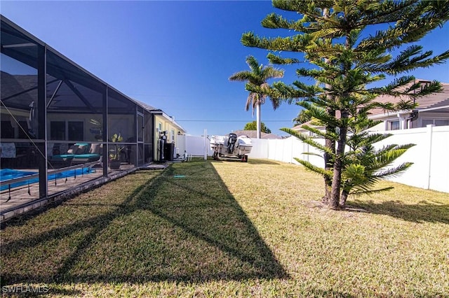 view of yard with a fenced in pool and glass enclosure