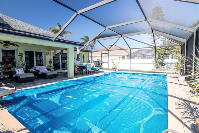 view of swimming pool with outdoor lounge area, a lanai, ceiling fan, and a patio area