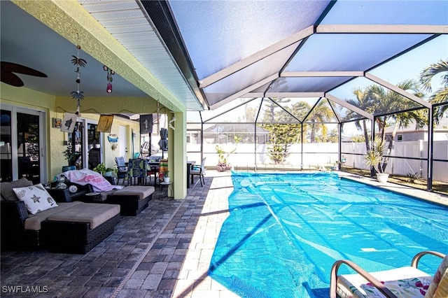 view of swimming pool featuring ceiling fan, a patio area, and glass enclosure