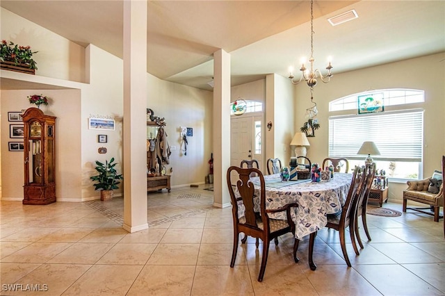 dining room with a healthy amount of sunlight, light tile patterned floors, and a chandelier