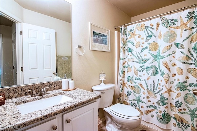 bathroom with tile patterned flooring, vanity, toilet, and walk in shower