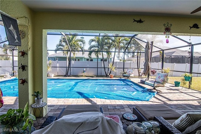 view of swimming pool featuring glass enclosure and a patio