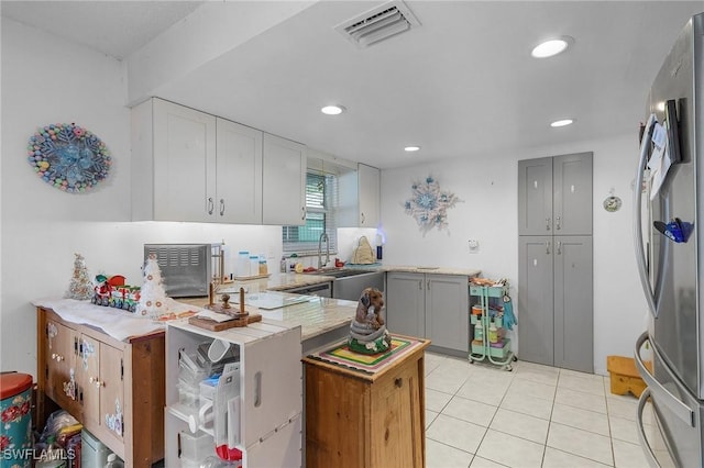 kitchen featuring gray cabinetry, sink, light tile patterned flooring, kitchen peninsula, and stainless steel refrigerator