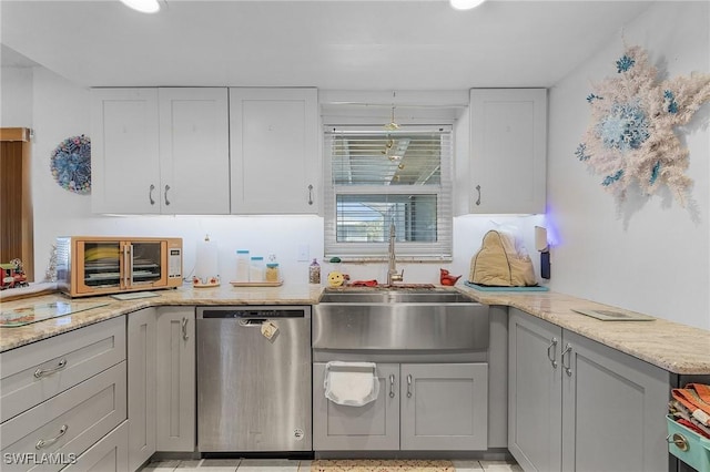 kitchen featuring dishwasher, gray cabinets, light stone countertops, and sink