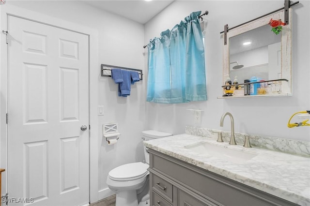 bathroom featuring vanity, toilet, and a shower