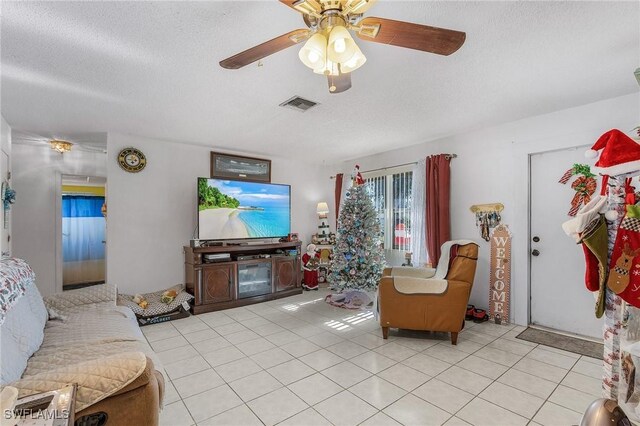 tiled living room featuring ceiling fan and a textured ceiling