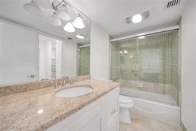 full bathroom with shower / bath combination with glass door, tile patterned floors, vanity, and toilet