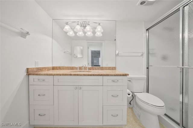 bathroom with tile patterned floors, vanity, toilet, and a shower with shower door