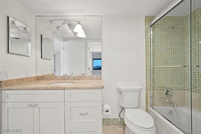 full bathroom featuring tile patterned flooring, vanity, toilet, and shower / bath combination with glass door