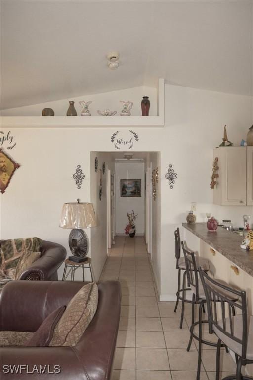 living room with light tile patterned floors and vaulted ceiling