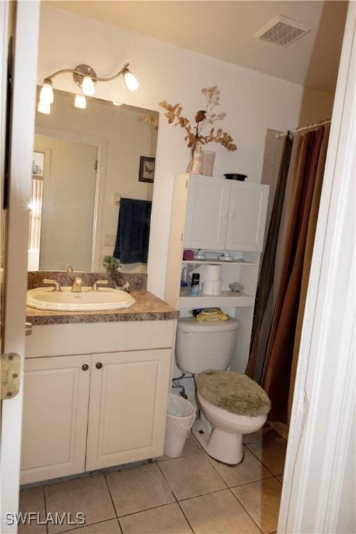 bathroom with tile patterned floors, vanity, toilet, and walk in shower