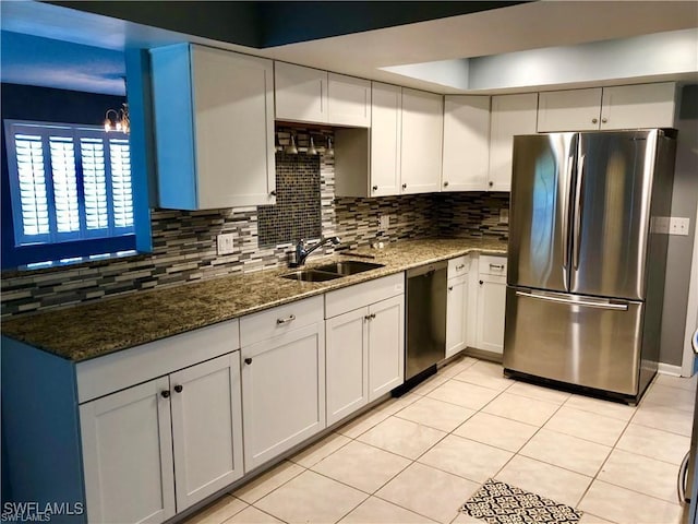 kitchen with backsplash, dark stone countertops, white cabinetry, and stainless steel appliances