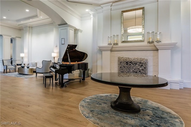 misc room with light wood-type flooring, ornate columns, and crown molding