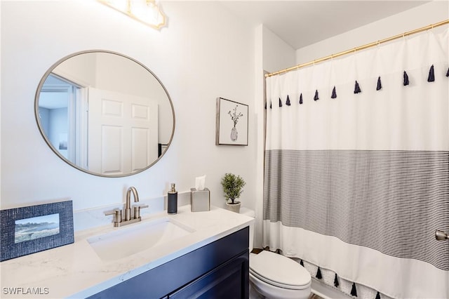 bathroom with vanity, curtained shower, and toilet