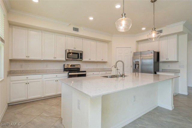 kitchen featuring a center island with sink, appliances with stainless steel finishes, white cabinets, decorative light fixtures, and sink