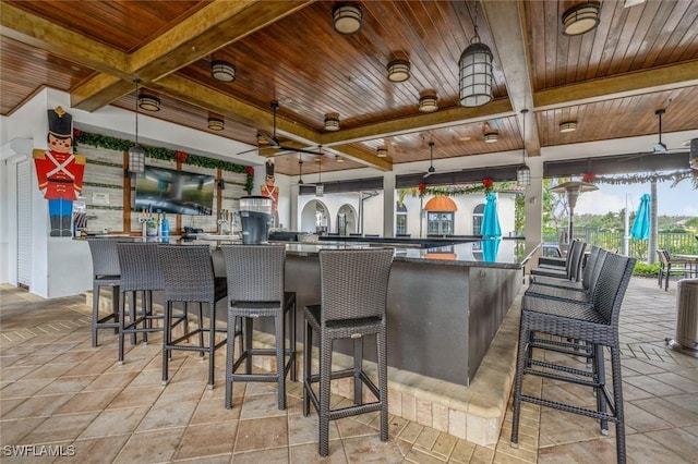 kitchen with a kitchen bar, wood ceiling, and hanging light fixtures