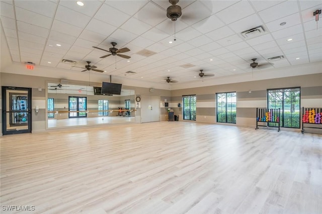 exercise area with a drop ceiling and light hardwood / wood-style flooring