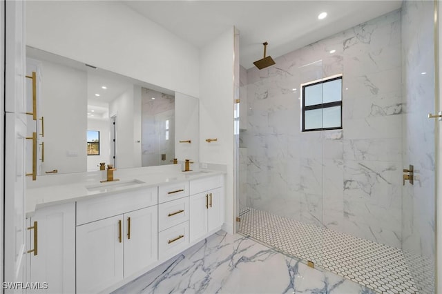 bathroom with a tile shower, vanity, and a healthy amount of sunlight