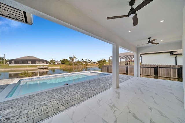 view of swimming pool featuring ceiling fan, a water view, and a patio