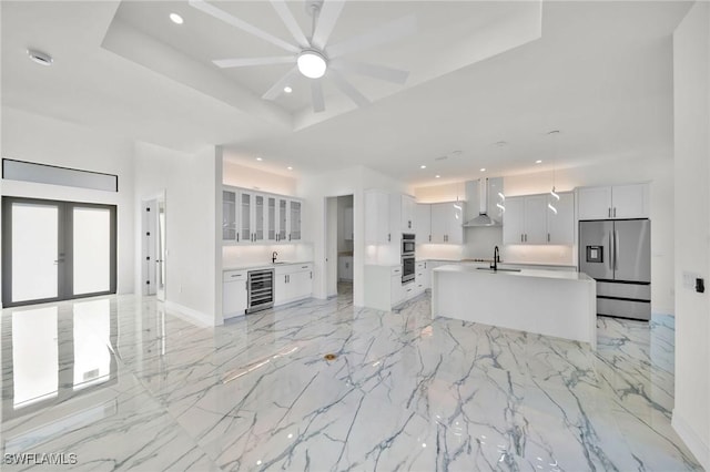 unfurnished living room featuring a raised ceiling, wine cooler, ceiling fan, and sink