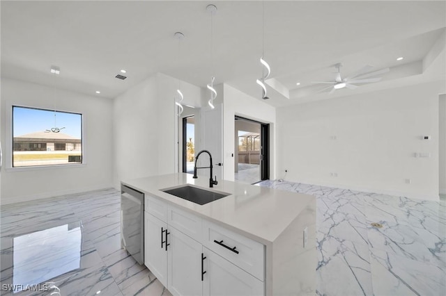 kitchen with white cabinets, a center island with sink, sink, stainless steel dishwasher, and decorative light fixtures