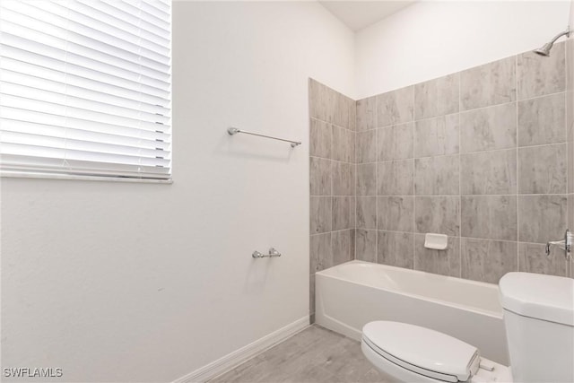 bathroom featuring tiled shower / bath and toilet