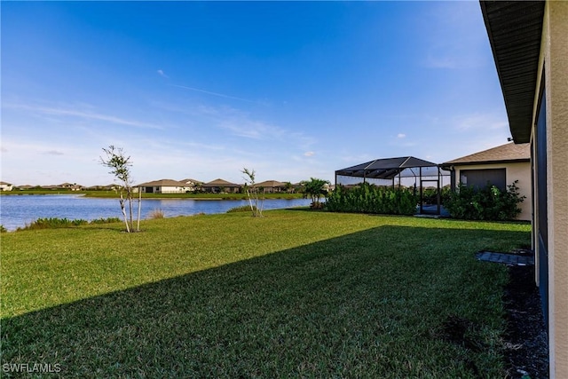 view of yard featuring glass enclosure and a water view