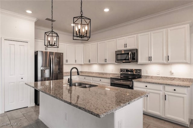 kitchen featuring sink, white cabinets, stainless steel appliances, and a center island with sink