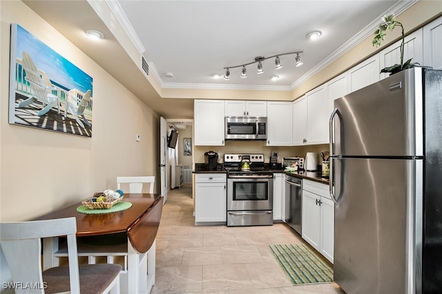 kitchen with crown molding, rail lighting, white cabinets, and appliances with stainless steel finishes