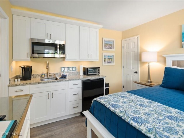 bedroom with sink and light hardwood / wood-style flooring