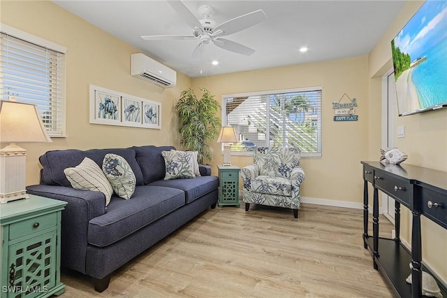 living room featuring ceiling fan, a wall mounted AC, and light wood-type flooring