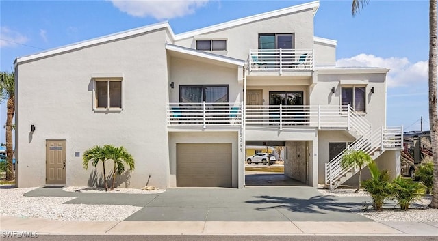 view of front of property featuring a garage, a balcony, and a carport