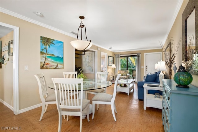 dining room with crown molding and light hardwood / wood-style flooring