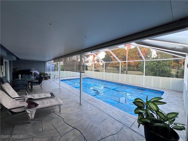 view of swimming pool featuring glass enclosure and a patio area