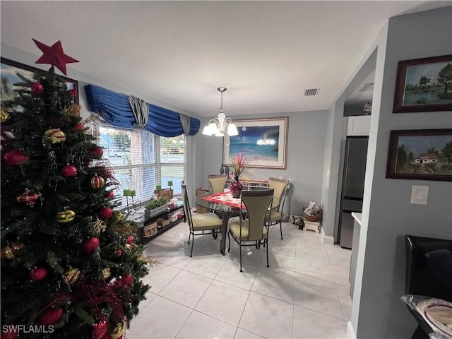 dining room with light tile patterned floors and a notable chandelier