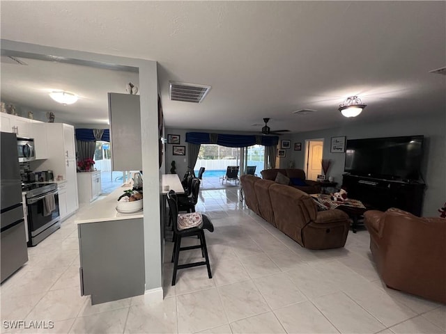 tiled living room with ceiling fan