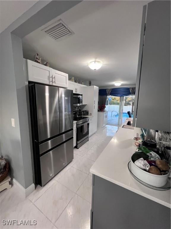 kitchen featuring white cabinetry and appliances with stainless steel finishes