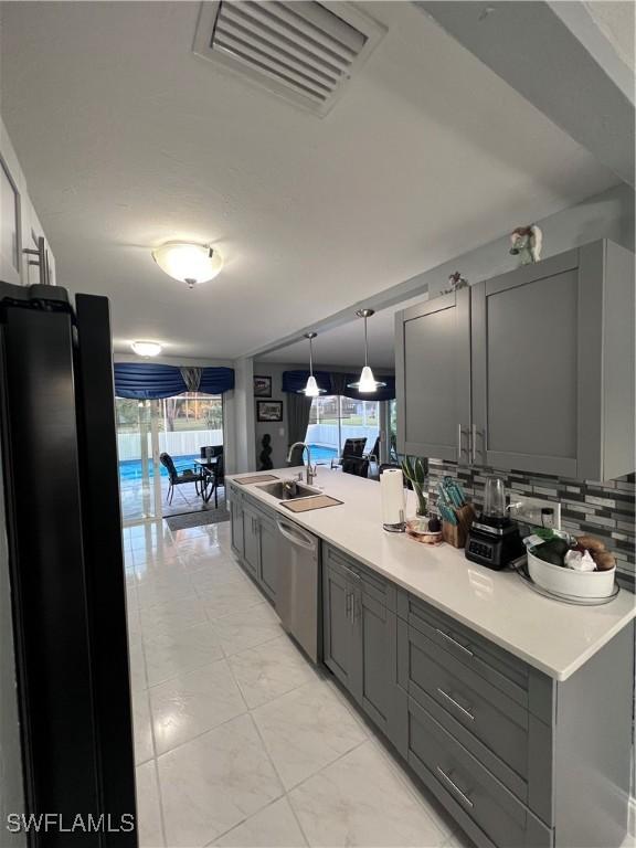 kitchen with dishwasher, gray cabinets, a healthy amount of sunlight, and sink