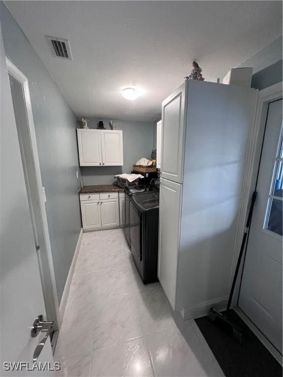 kitchen featuring white cabinetry and washer and clothes dryer