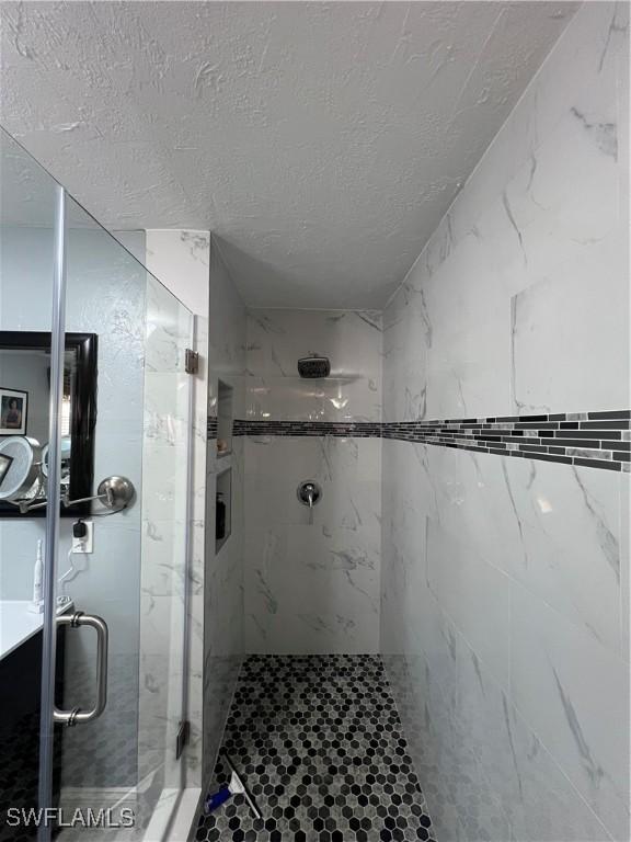 bathroom featuring a textured ceiling and walk in shower