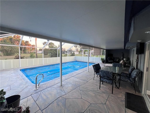 pool at dusk with a lanai and a patio area