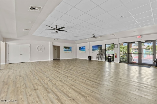 interior space featuring a paneled ceiling, ceiling fan, french doors, and light wood-type flooring