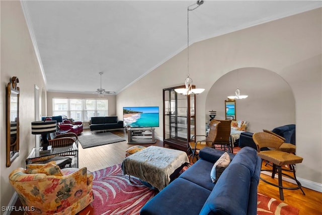 living room with lofted ceiling, crown molding, wood-type flooring, and ceiling fan with notable chandelier