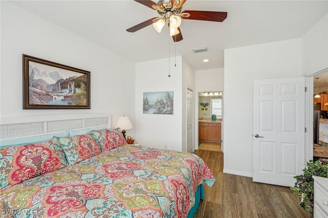 bedroom featuring stainless steel fridge, dark hardwood / wood-style flooring, ensuite bathroom, and ceiling fan