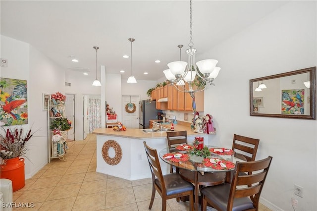 dining room featuring a notable chandelier, light tile patterned flooring, a towering ceiling, and sink