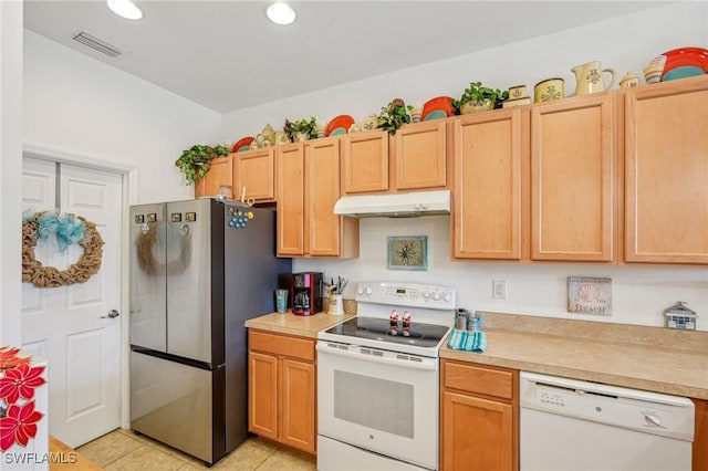 kitchen featuring light tile patterned flooring, white appliances, and light brown cabinetry