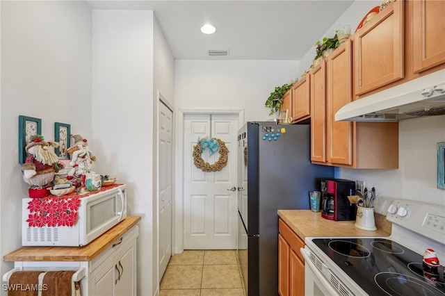 kitchen featuring light tile patterned flooring and white appliances