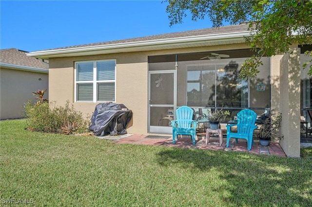 rear view of house featuring a sunroom, a yard, and ceiling fan