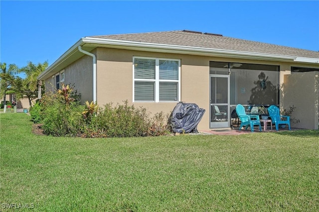 rear view of property featuring a lawn