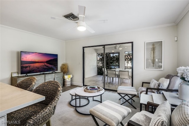 living room featuring ceiling fan, wood-type flooring, and crown molding